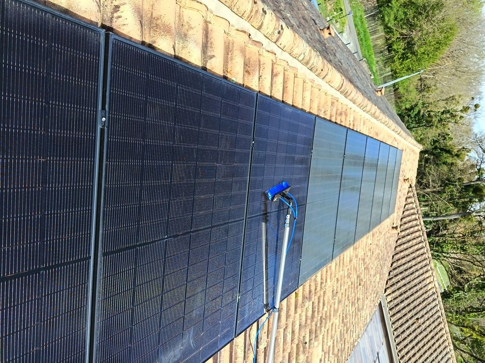 Nettoyage de panneaux solaires en cours : à gauche, zone déjà nettoyée ; à droite, zone encore sale.