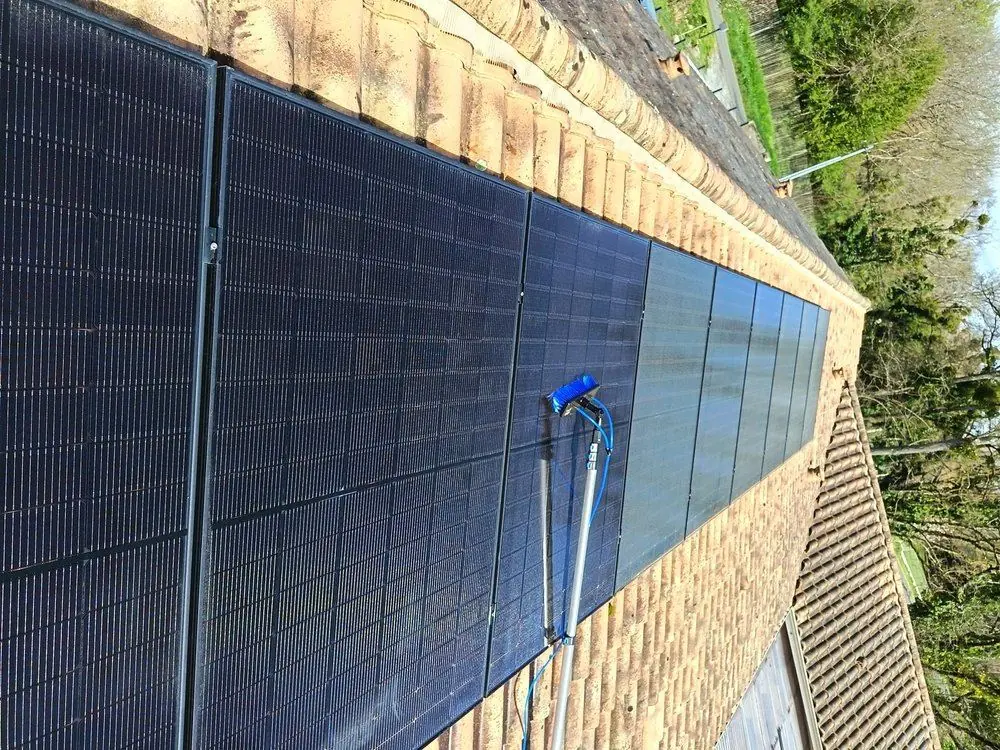 Nettoyage de panneaux solaires en cours : à gauche, zone déjà nettoyée ; à droite, zone encore sale.