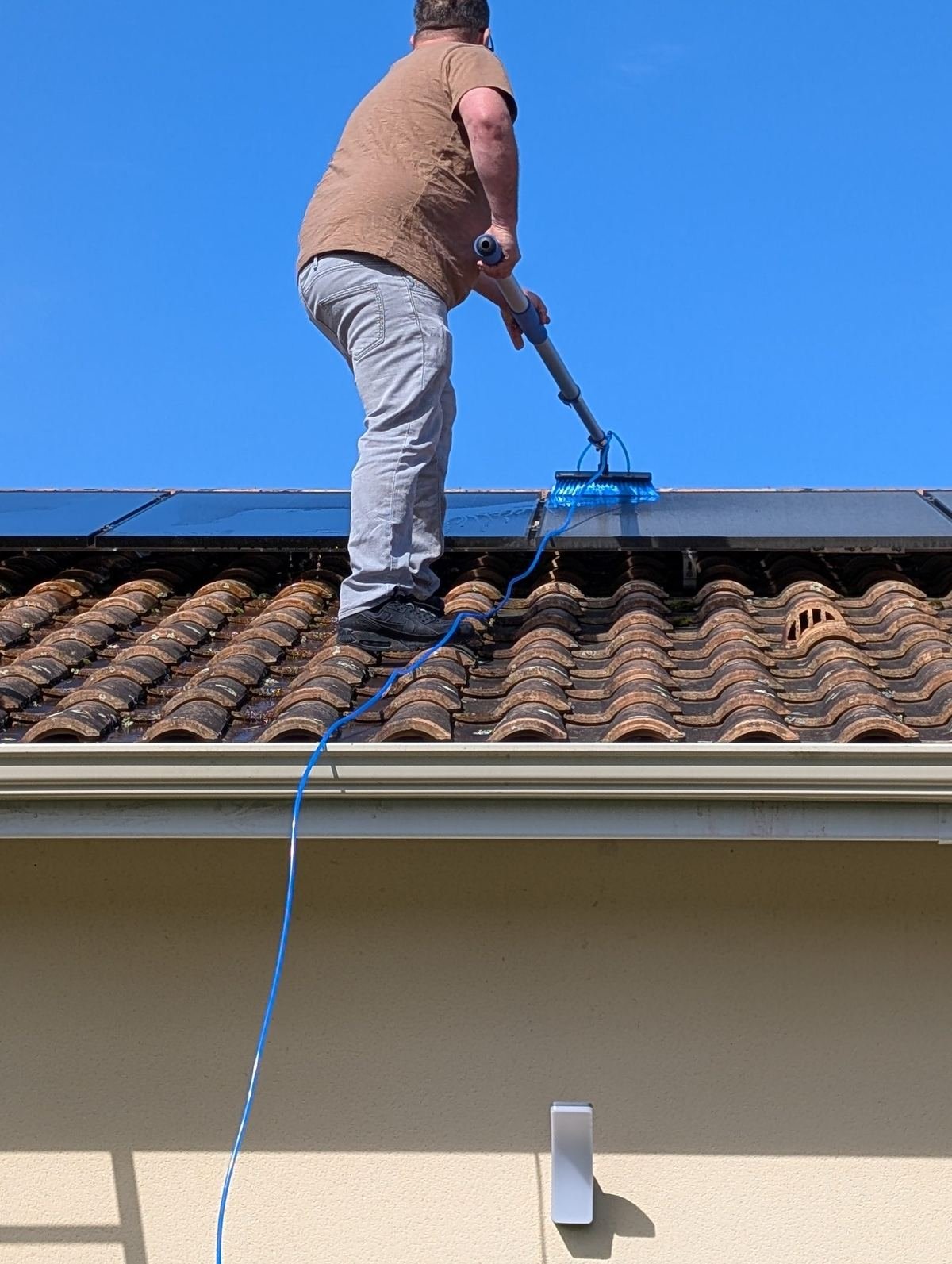 Technicien DAE Services 33 nettoyant des panneaux solaires à l'eau osmosée